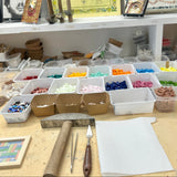 Workbench with mosaic  supplies and artwork in a workshop setting